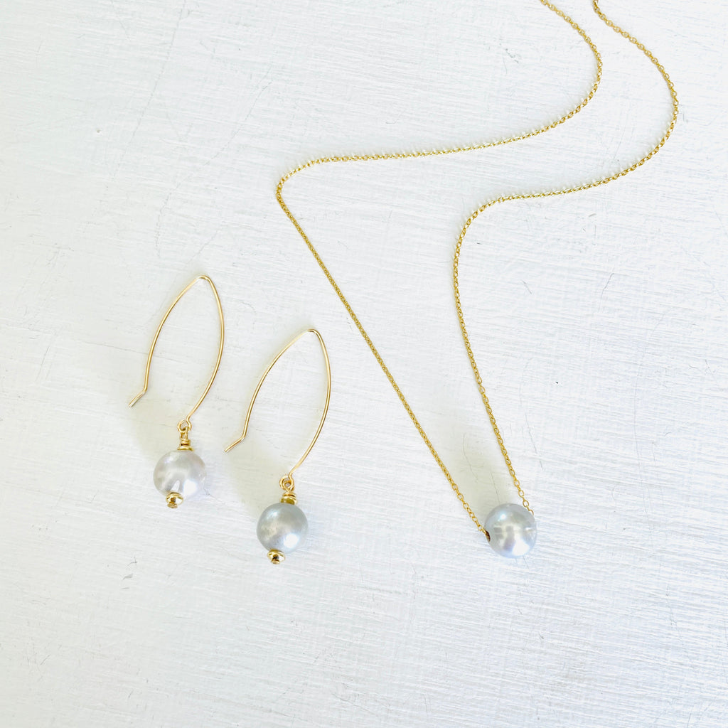 ZEN by Karen Moore Long Loop Gold Earrings with Grey Pearls on White Background