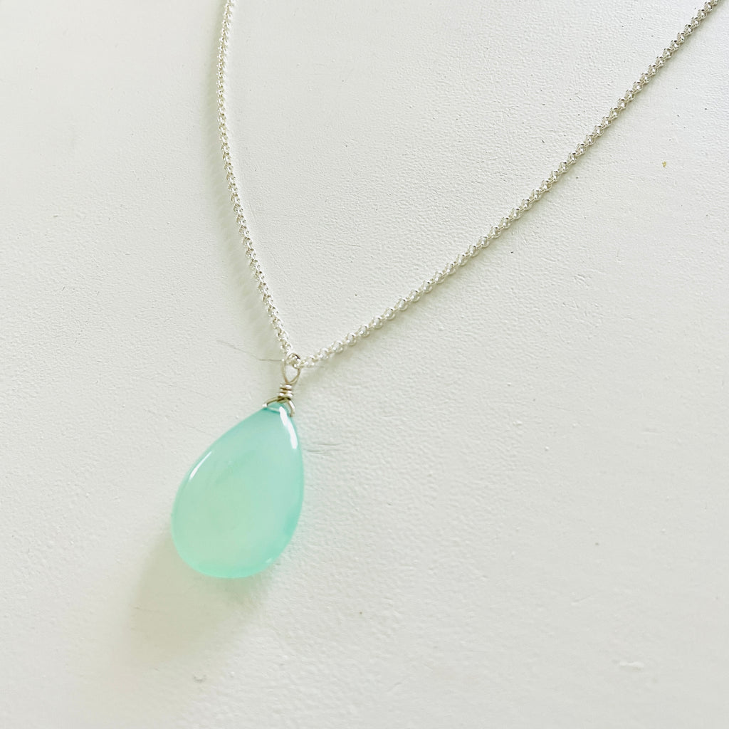 The Harmony & Joy Chalcedony Pendant Necklace on silver chain by ZEN by Karen Moore on white wood background