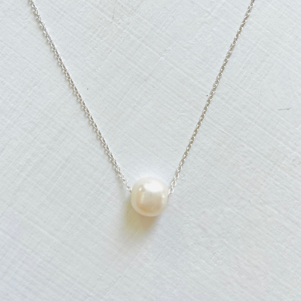 Floating Pearl Adjustable Necklace by ZEN by Karen Moore with gold chain on white background showing pearl gemstone