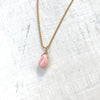 Delicate Inspiration conch shell necklace in 14K gold by ZEN Karen Moore on white wood