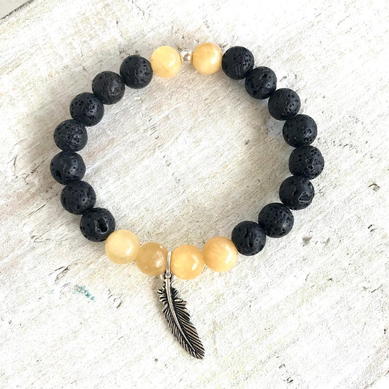 Calcite & lava stone Power Of The Positive Aromatherapy Bracelet by ZEN by Karen Moore on white wood