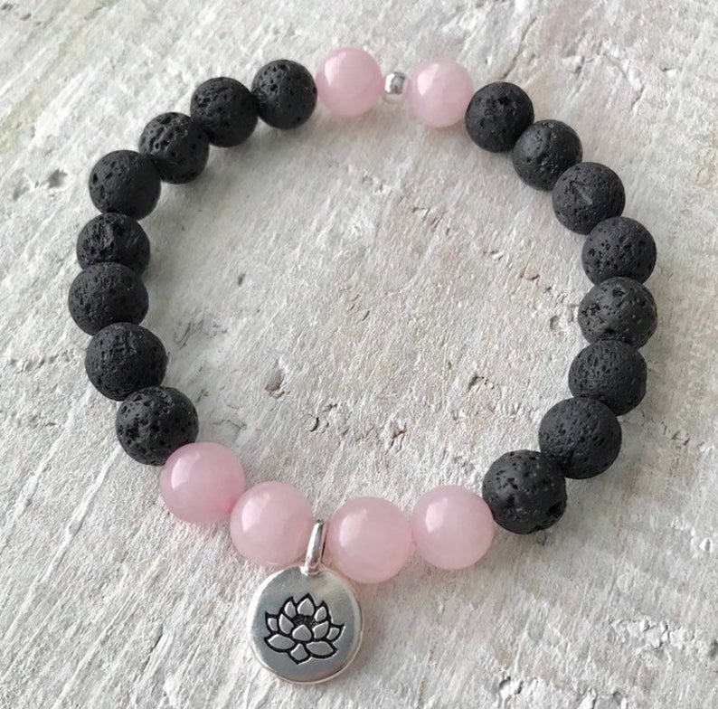 Rose quartz & lava stone Lotus Love Aromatherapy Bracelet by ZEN by Karen Moore close up on white wood