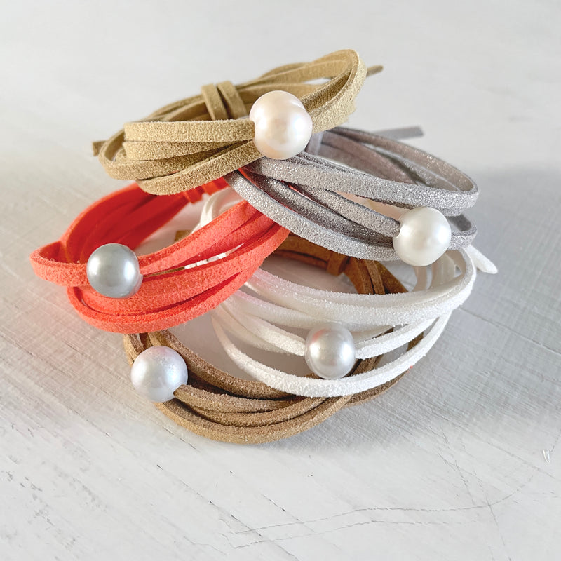 Five Freshwater Pearl Eco ZEN Wraps on white wood background
