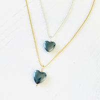 Hematite gemstone charm necklace on ball chain on a white background