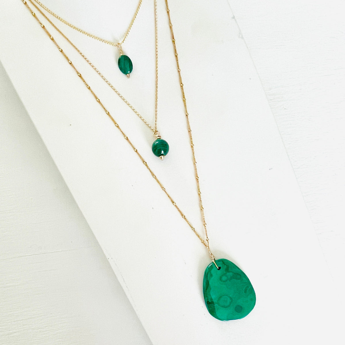 ZEN by Karen Moore green Malachite gemstone necklaces on gold chain on white background