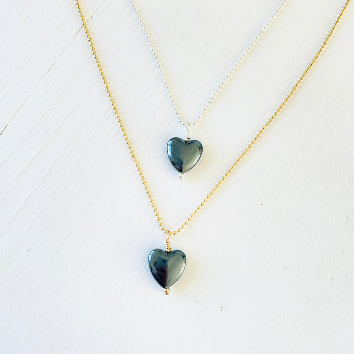 Hematite gemstone charm necklace on ball chain on a white background