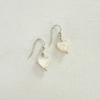 Heart-shaped earrings on a light fabric background