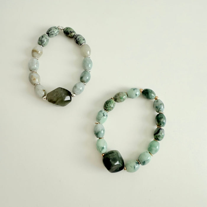 Two beaded bracelets with green and gray stones on a light background