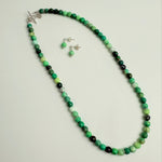 Earrings & Necklace with green and black beads on a white background