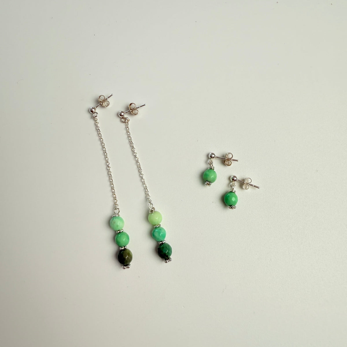 Beaded necklace and earrings on a light gray background