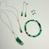 Jewelry set with necklace, bracelet, and earrings on a light gray background