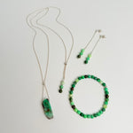 Two green beaded necklaces on a white background