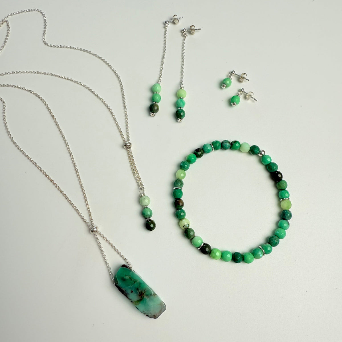 Set of green and black beaded jewelry on a light gray background