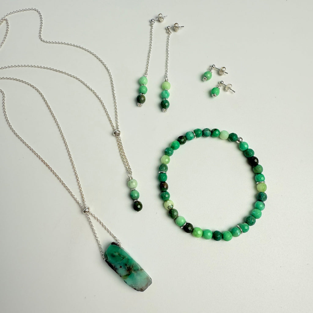 Set of green and black beaded jewelry on a light gray background
