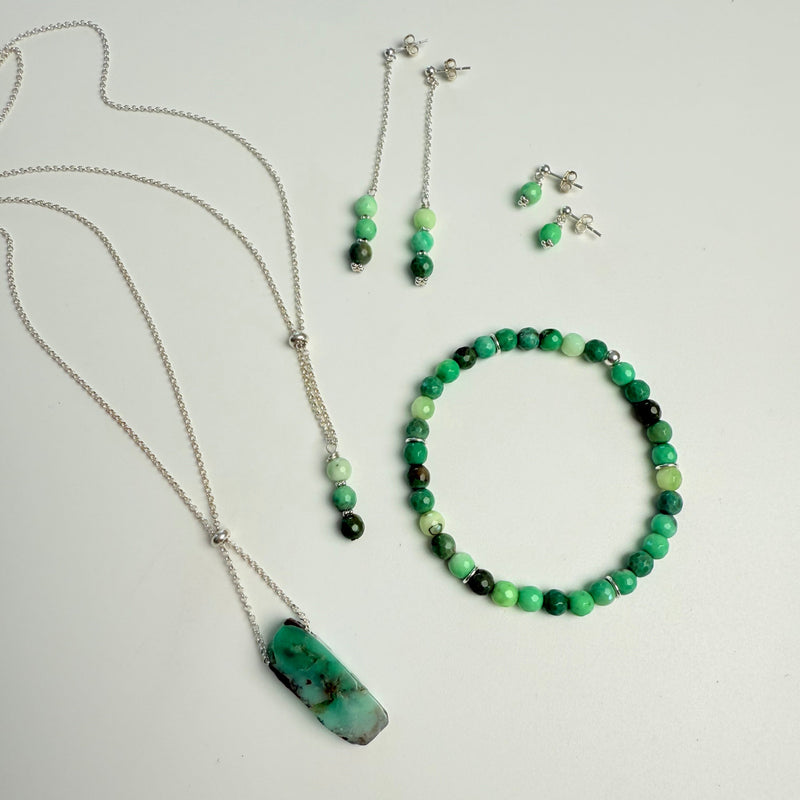 Set of green and black beaded jewelry on a light gray background