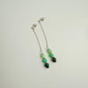 Beaded bracelet with green and black beads on a light gray background