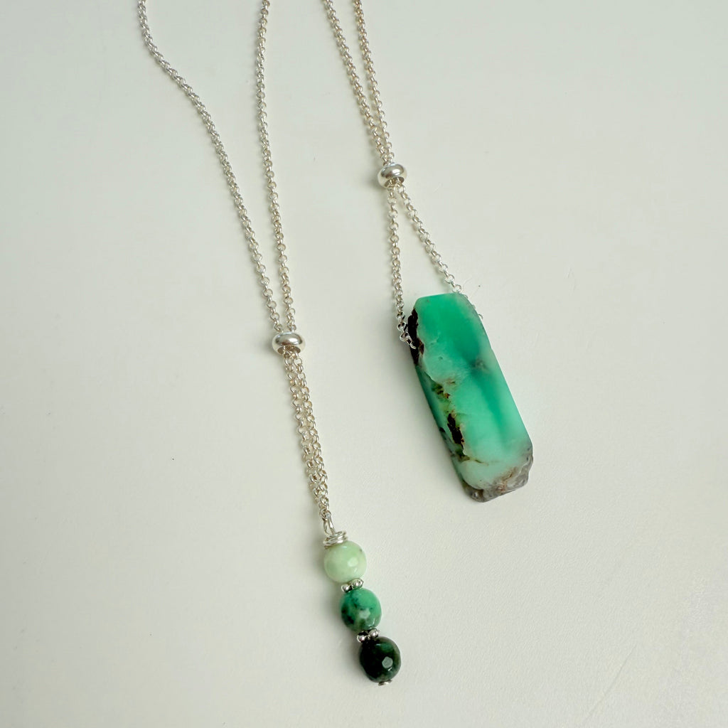Necklace with a green pendant and beads on a white background