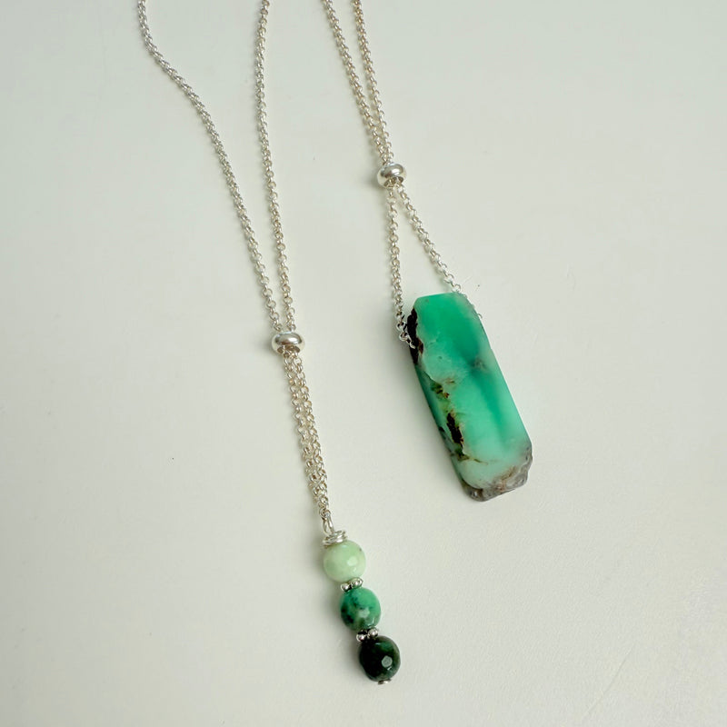 Necklace with a green pendant and beads on a white background
