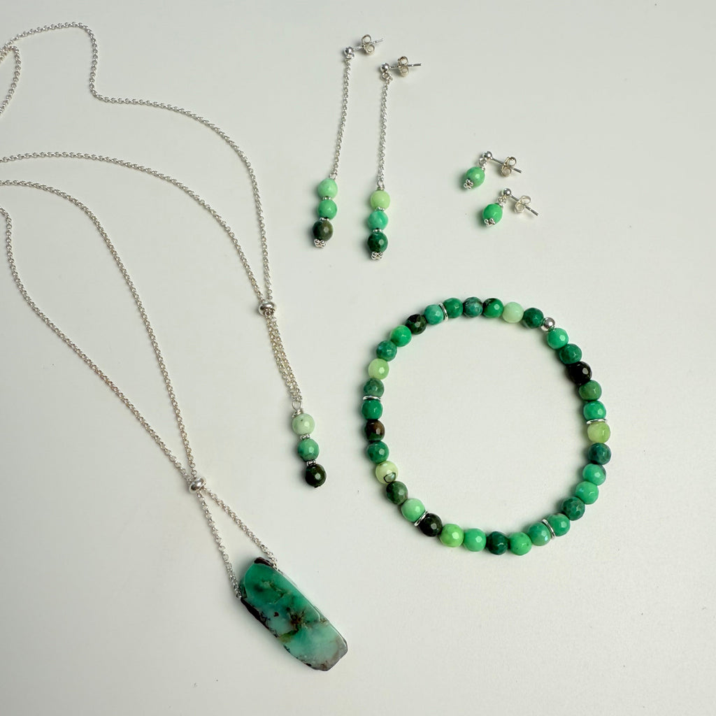 Set of green and black beaded jewelry on a light gray background