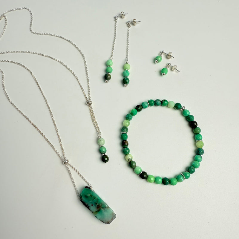 Set of green and black beaded jewelry on a light gray background