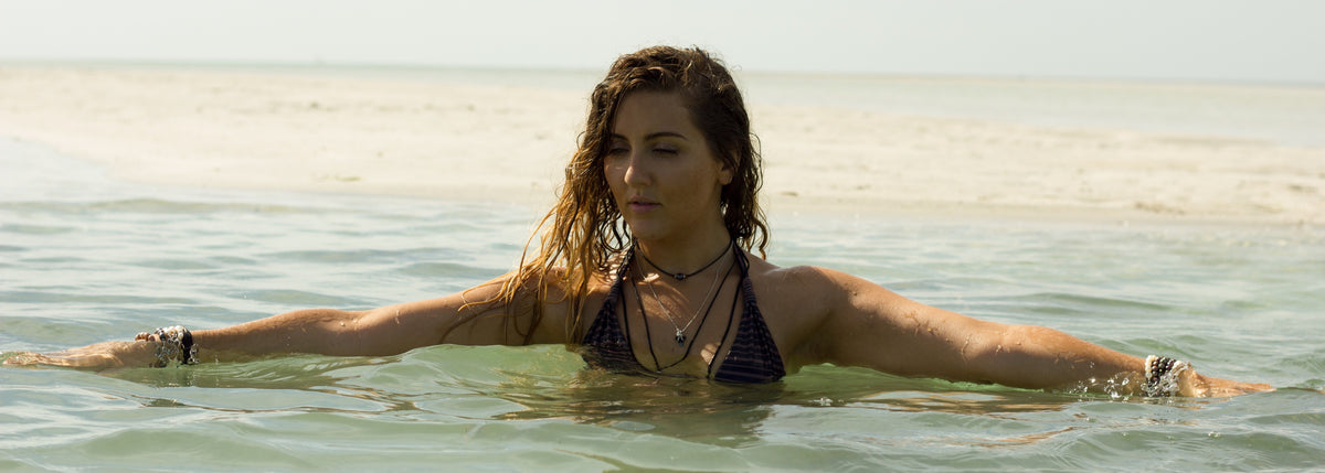 woman in the ocean wearing ZEN by Karen Moore jewelry