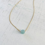 The Jenny Blues Amazonite Necklace by ZEN by Karen Moore by on white wood emphasizing the gemstone