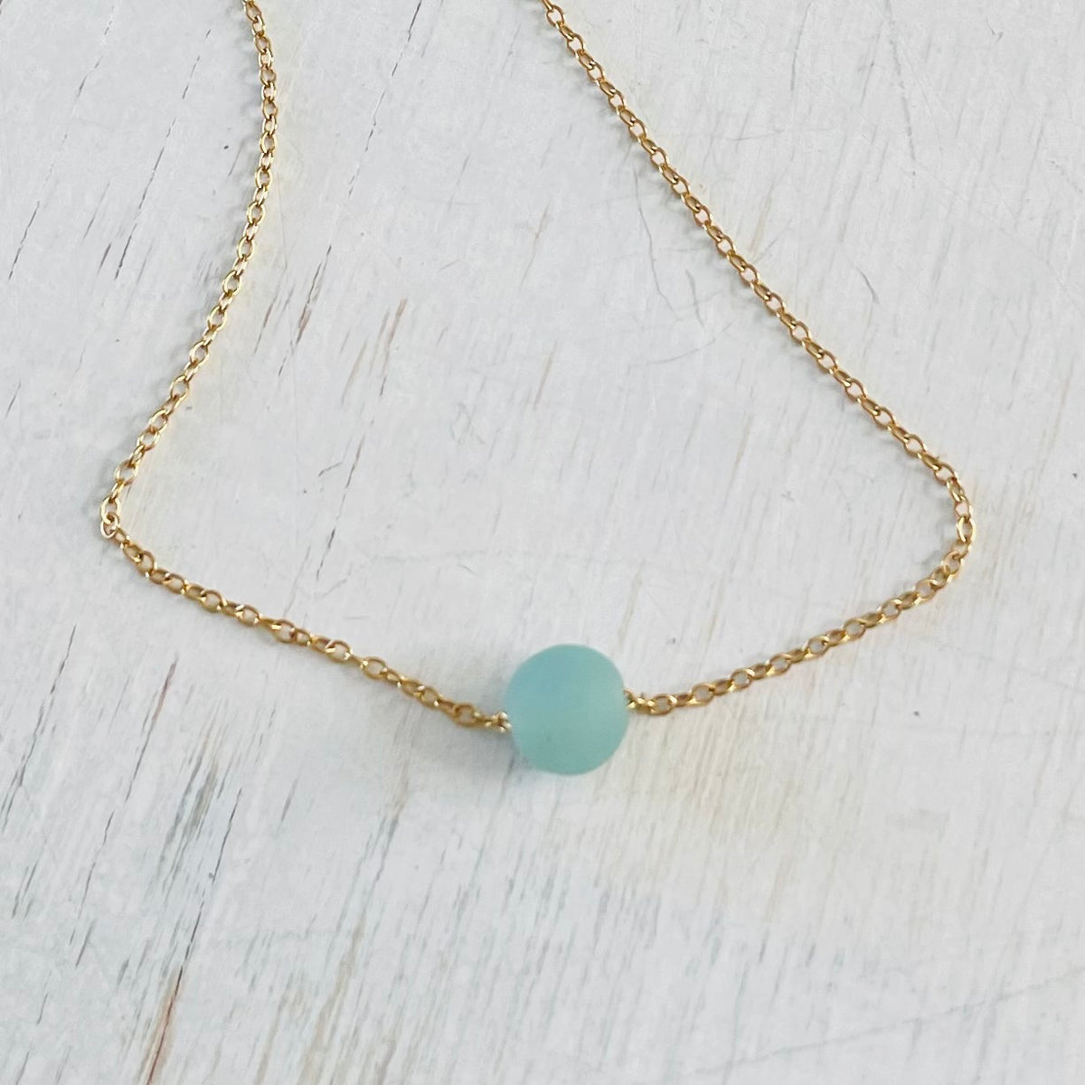 The Jenny Blues Amazonite Necklace by ZEN by Karen Moore on white wood showing blue stone