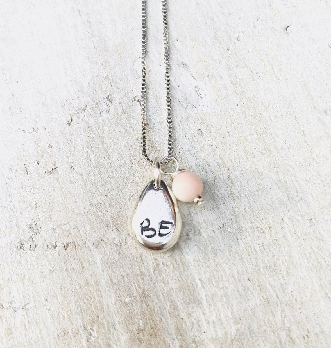 Just BE Free Charm Necklace by ZEN by Karen Moore Jewelry alternate close up of charms on white wood