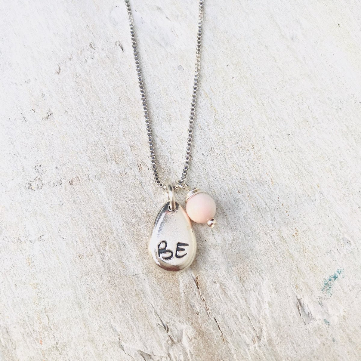 Just BE Free Charm Necklace by ZEN by Karen Moore Jewelry alternate close up of charms on white wood