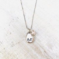 Just BE Love Charm Necklace by ZEN by Karen Moore Jewelry close up of charms on white wood