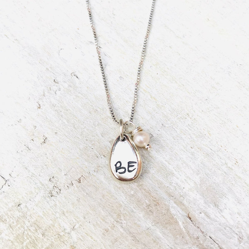 Just BE Love Charm Necklace by ZEN by Karen Moore Jewelry close up of charms on white wood