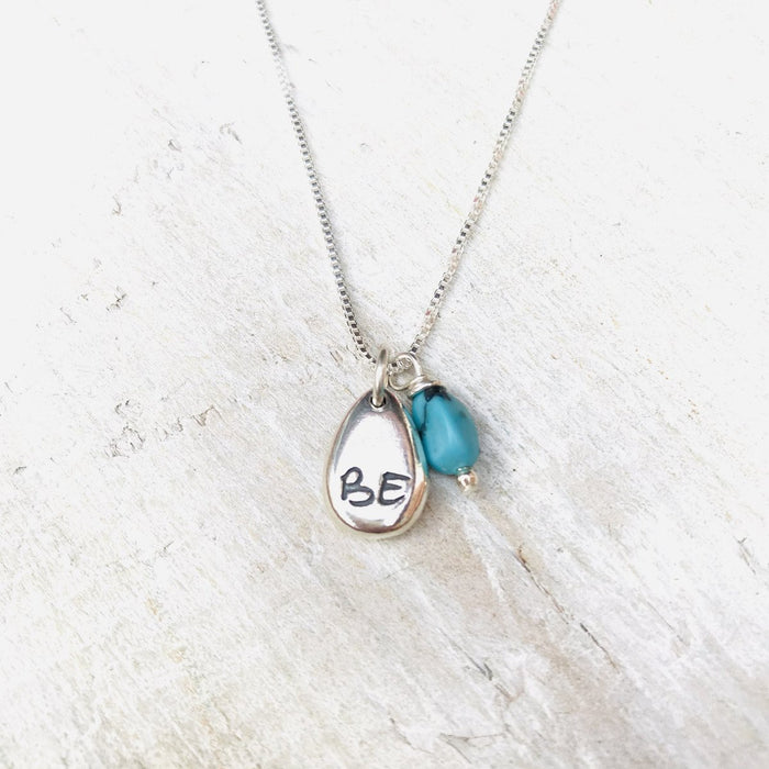 Just BE Bold Charm Necklace by ZEN by Karen Moore Jewelry close up of charms on white wood