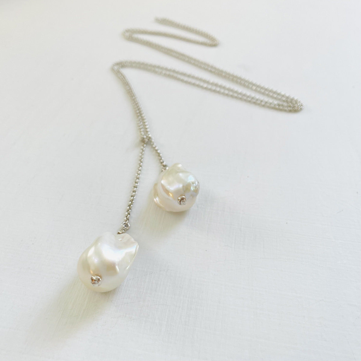 Wisdom Within ZEN Wrap Necklace by ZEN by Karen Moore Jewelry showing close up of pearls and chain zig-zagged on a white background