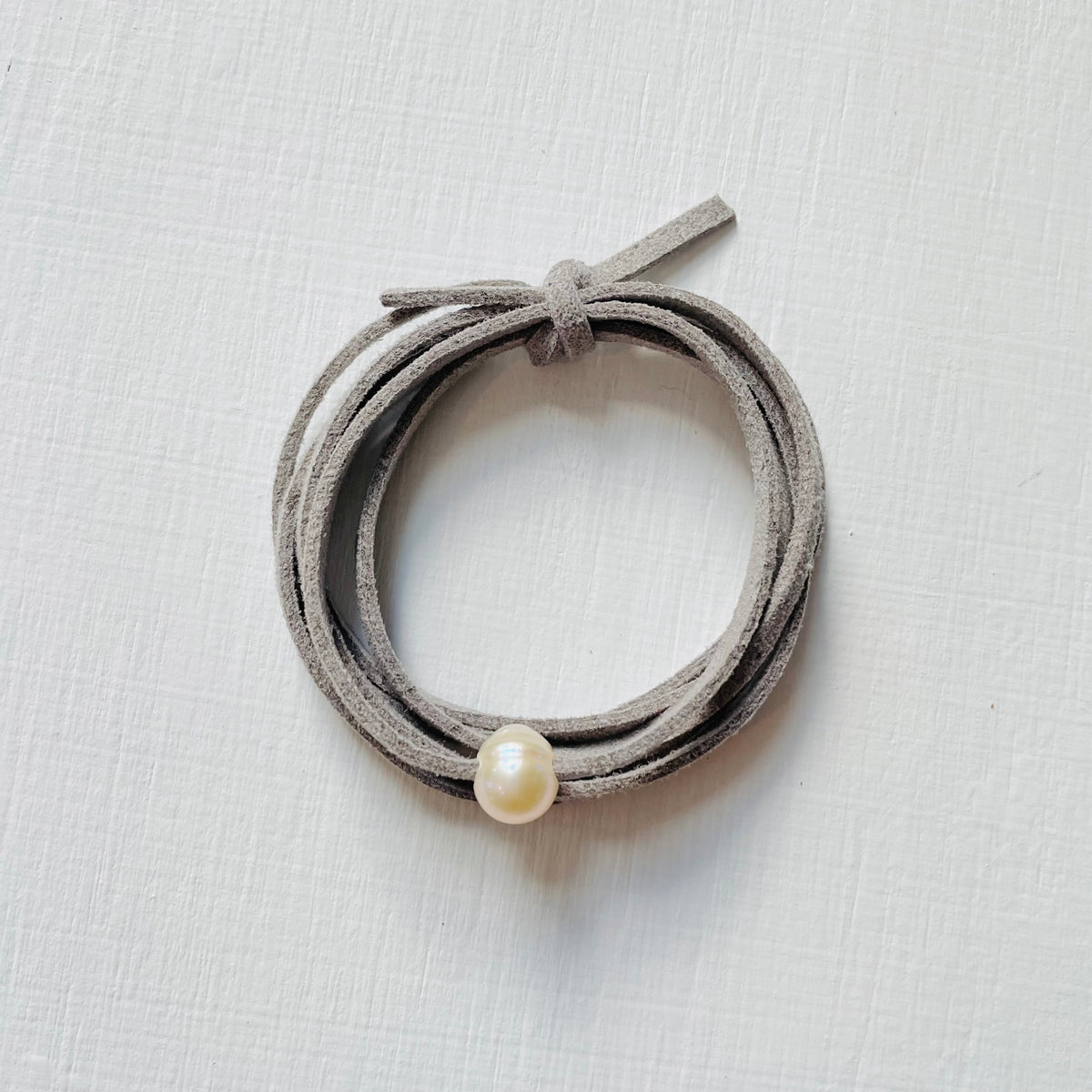 Pearl Of Wisdom Cool Stone Eco Zen Wrap Jewelry by ZEN by Karen Moore overhead view on white wood