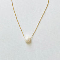 Floating Pearl Adjustable Necklace by ZEN by Karen Moore with gold chain on white background showing pearl gemstone