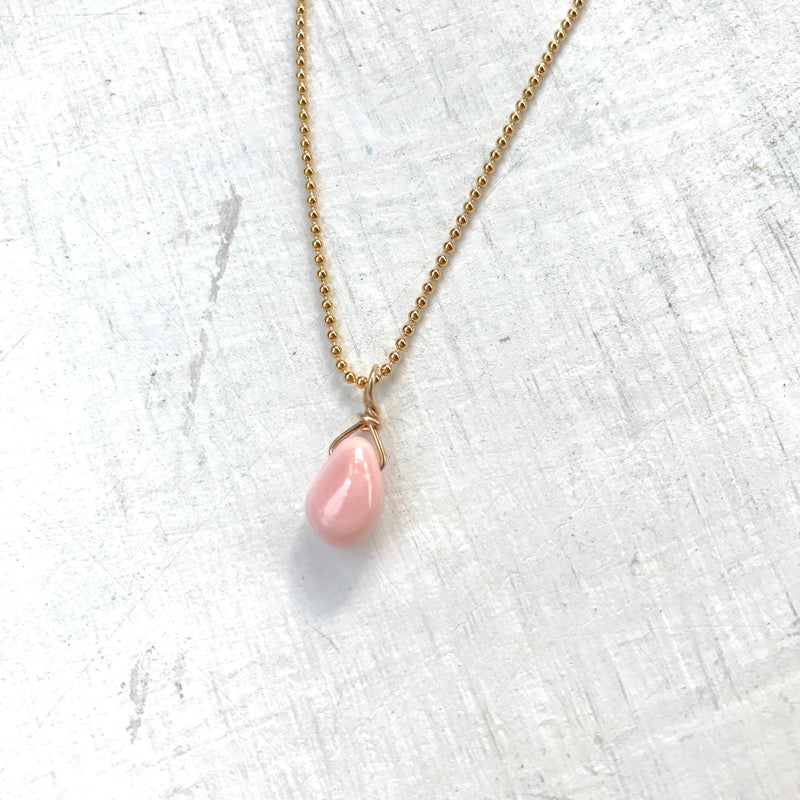 Delicate Inspiration conch shell necklace in 14K gold by ZEN Karen Moore on white wood