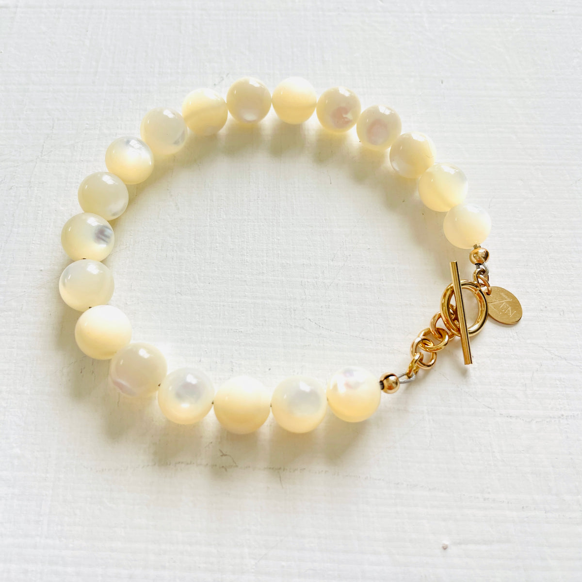 Nurtured by Nature Mother of Pearl Bracelet with 14K gold clasp by ZEN by Karen Moore jewelry zoomed overhead view on white background