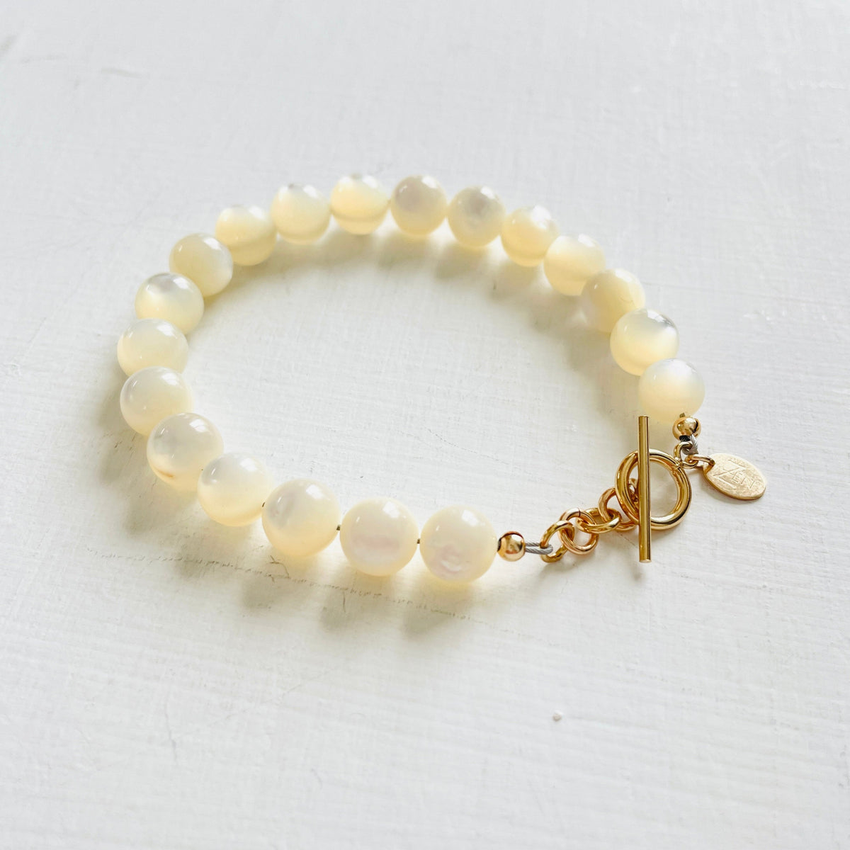 Nurtured by Nature Mother of Pearl Bracelet with 14K gold clasp by ZEN by Karen Moore jewelry angled view on white background