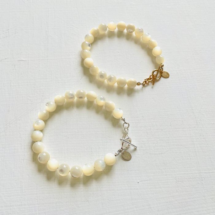 two Nurtured by Nature Mother of Pearl Bracelets, one with 14K gold clasp and the other with sterling silver clasp, by ZEN by Karen Moore jewelry on white background