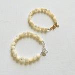 two Nurtured by Nature Mother of Pearl Bracelets, one with 14K gold clasp and the other with sterling silver clasp, by ZEN by Karen Moore jewelry on white background