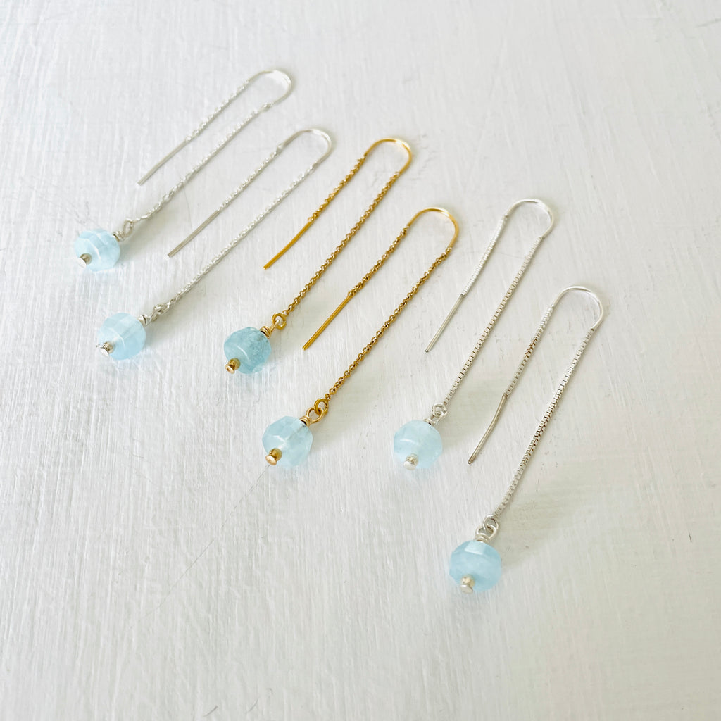 Drop into the Calm Aquamarine Earrings by ZEN by Karen Moore jewelry showing two pairs in sterling silver with a pair in 14K gold in the middle angled view on white background