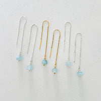 Drop into the Calm Aquamarine Earrings by ZEN by Karen Moore jewelry showing two pairs in sterling silver with a pair in 14K gold in the middle overhead view on white background