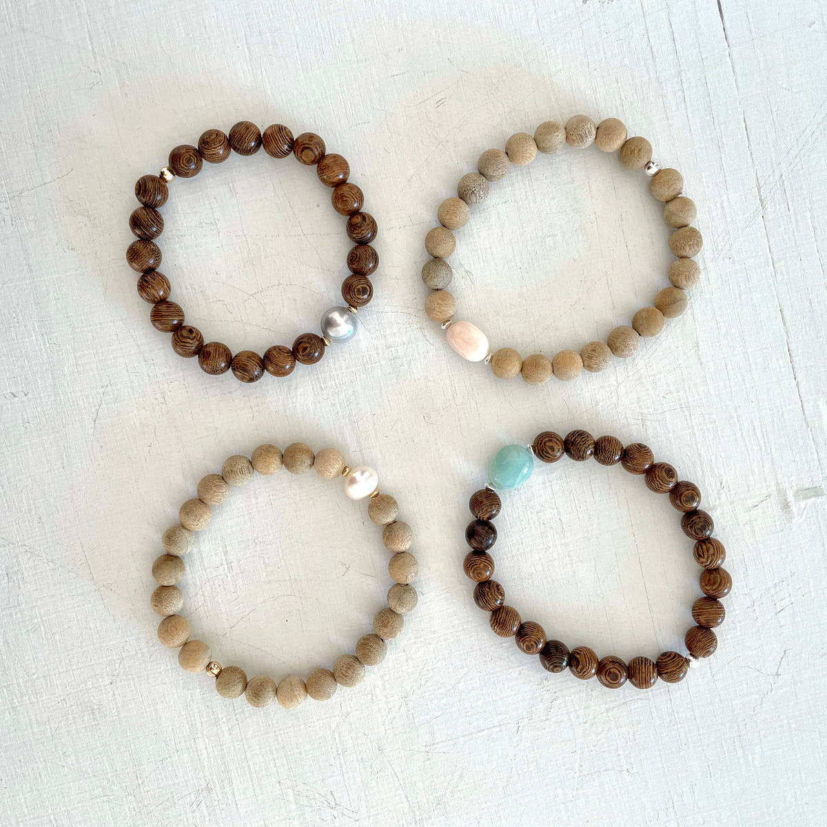 Mojo Sandalwood & Tiger Wood Bracelet group by ZEN by Karen Moore on white wood background