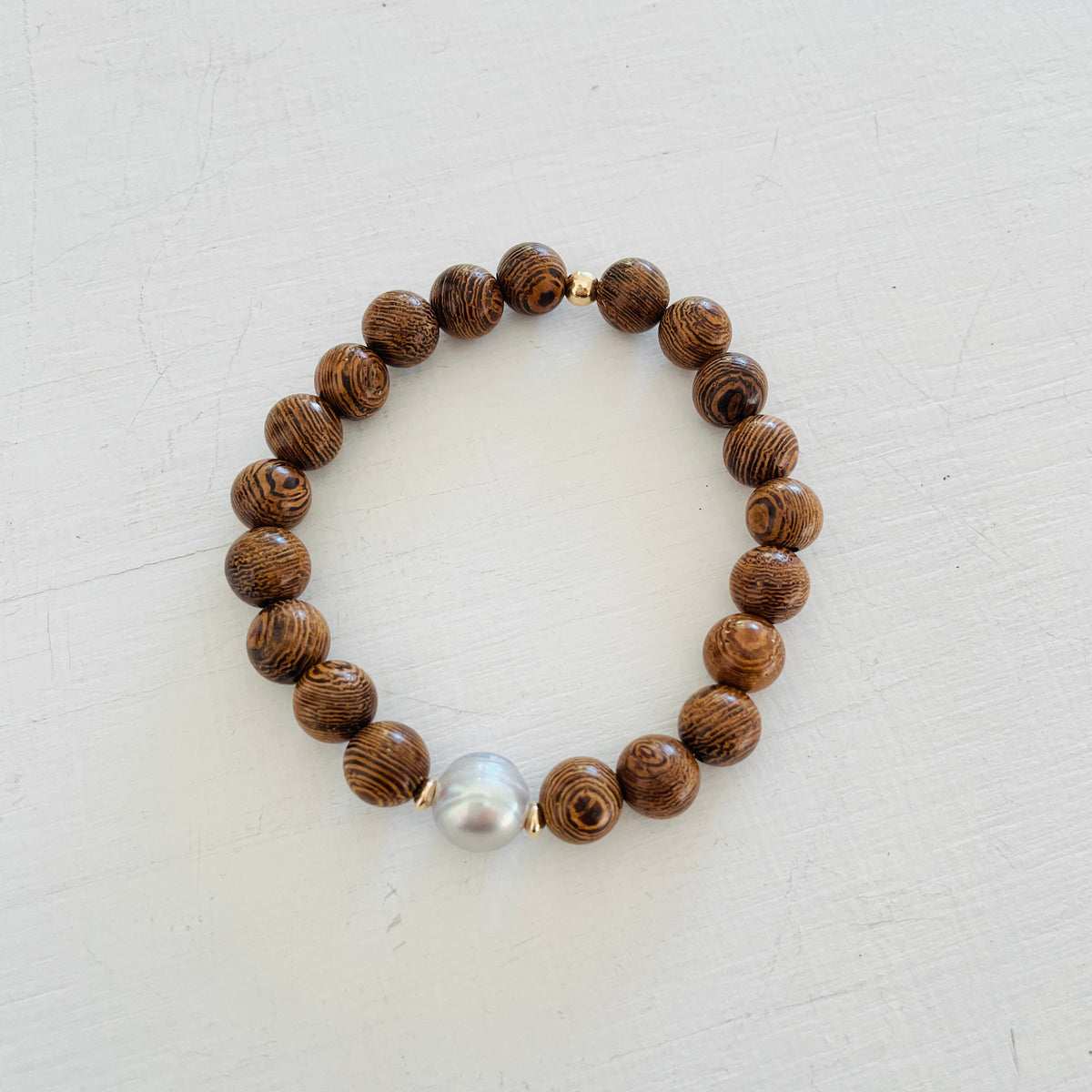 Mojo Grey Pearl Tiger Wood Bracelet by ZEN by Karen Moore on white wood background