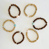 Mojo Tiger Wood & Sandalwood Bracelet group by ZEN by Karen Moore laid out in a circle on white wood background
