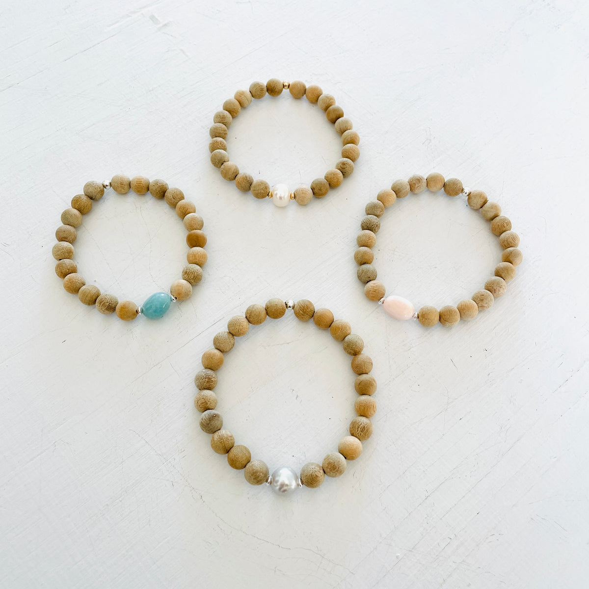 Mojo Sandalwood Bracelet group by ZEN by Karen Moore on white wood background