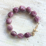 Let That Shit Go Lepidolite Bracelet with gold clasp by ZEN by Karen Moore overhead view on white wood