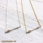 You're Going The Right Way Arrow Necklace in silver and gold/silver by ZEN by Karen Moore on white wood