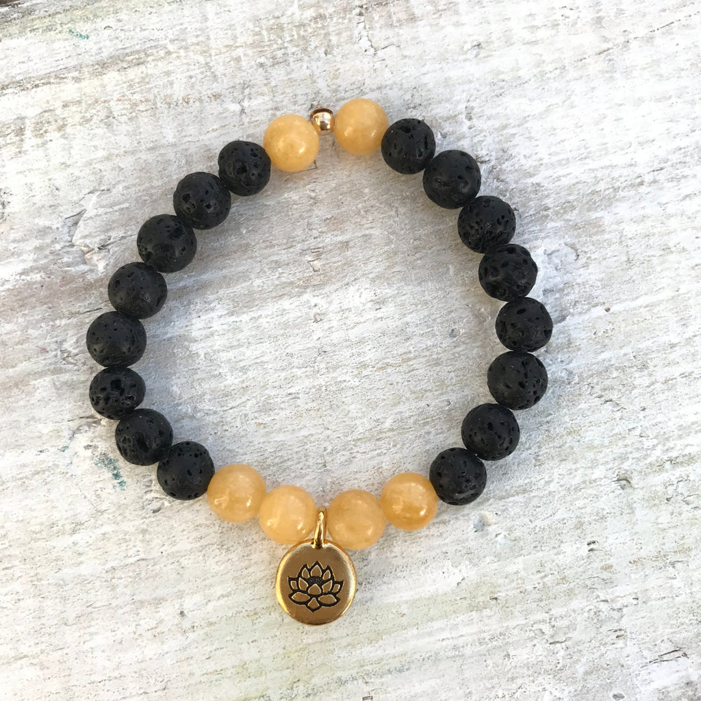 Calcite & lava stone Be Positive Aromatherapy Bracelet by ZEN by Karen Moore on white wood