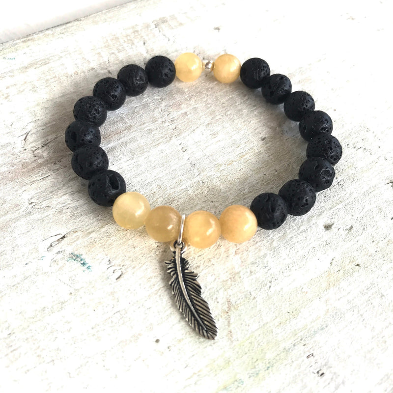Calcite & lava stone Power Of The Positive Aromatherapy Bracelet by ZEN by Karen Moore on white wood